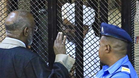 Sudan&#39;s deposed military president Omar al-Bashir in a defendant&#39;s cage during his corruption trial at a court in Khartoum on December 14, 2019.