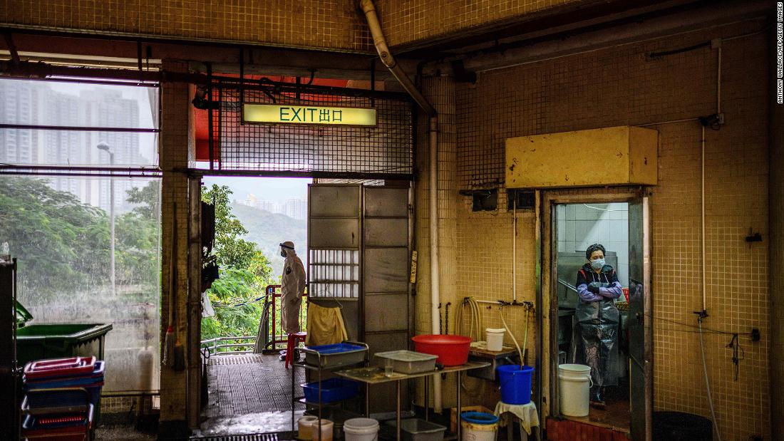 A police officer, left, wears protective gear as he guards a cordon at the Hong Mei House in Hong Kong on February 11, 2020.