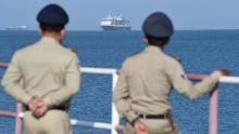 Authorities watch as the Westerdam cruise ship approaches a port in Sihanoukville, Cambodia, on Thursday, February 13. Despite having no confirmed cases of coronavirus on board, the Westerdam was refused port by four other Asian countries before being allowed to dock in Cambodia.