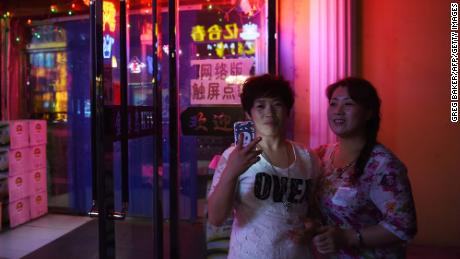 Two women outside a karaoke bar in Hunchun, in China&#39;s northeast Jilin province in 2015. 