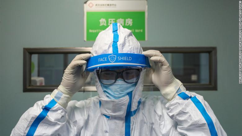 Um médico veste a roupa de isolamento antes de entrar na ala de isolamento de pressão negativa no Hospital Jinyintan em Wuhan.