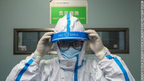 A doctor puts on the isolation outfit before entering the negative-pressure isolation ward in Jinyintan Hospital in Wuhan.