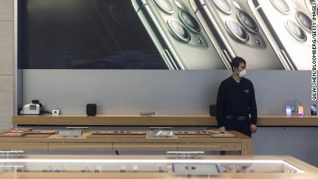 A security guard wearing a protective mask stands guard inside an Apple Inc. store in Shanghai, China, on Saturday, Feb. 15, 2020. 