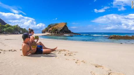 couple on sunny beach thanks to the best travel credit cards