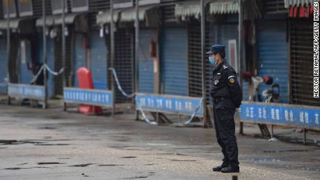 A security guard stands outside the Huanan Seafood Wholesale Market where the coronavirus was detected in Wuhan on January 24.