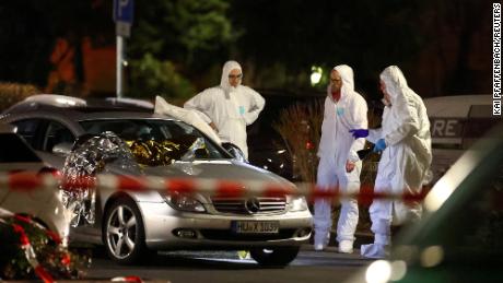 Forensic experts work around a damaged car after the attack in Hanau.