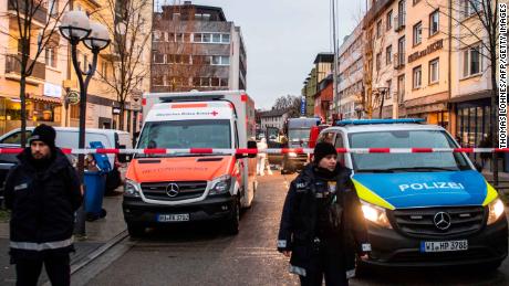 Police, emergency services and forensic police are seen behind a police cordon near a bar (L) in the centre of Hanau, near Frankfurt am Main, western Germany, on February 20, 2020, after at least nine people were killed in two shootings late on February 19. - At least nine people were killed in shootings targeting shisha bars in Germany that sparked a huge manhunt overnight before the suspected gunman was found dead in his home early on February 20. The attacks occurred at two bars in Hanau, about 20 kilometres (12 miles) from Frankfurt, where armed police quickly fanned out and police helicopters roamed the sky looking for those responsible for the bloodshed. Police in the central state of Hesse said the likely perpetrator had been found at his home in Hanau after they located a getaway vehicle seen by witnesses. Another body was also discovered at the property. German counter-terror prosecutors said on February 20 they had taken over the investigation into two linked shootings. (Photo by Thomas Lohnes / AFP) (Photo by THOMAS LOHNES/AFP via Getty Images)
