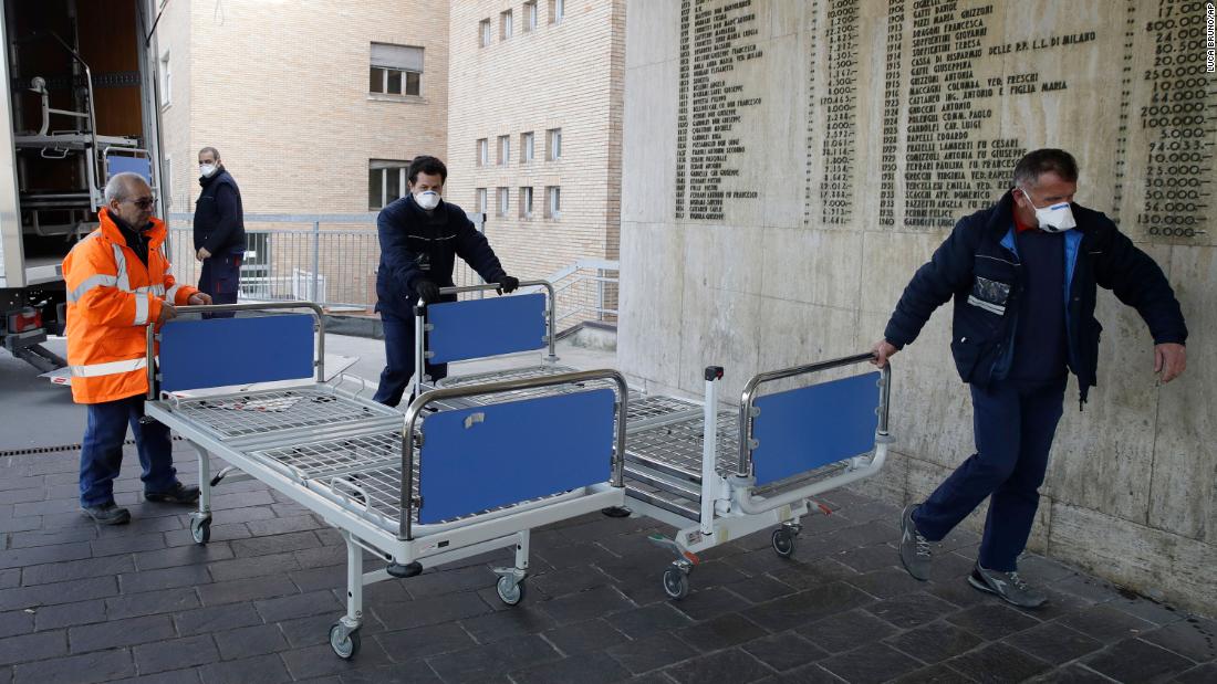 Hospital personnel in Codogno, Italy, carry new beds inside the hospital on February 21, 2020. The hospital was hosting some people who had been diagnosed with the novel coronavirus.