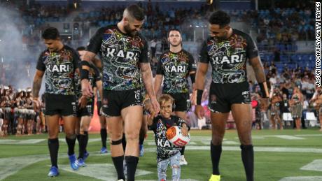 Bayles runs onto the field with the Indigenous All-Stars.