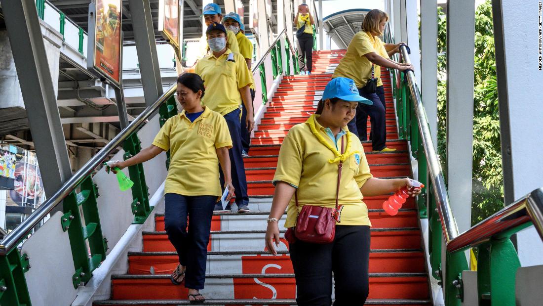 A team of volunteers disinfects a pedestrian bridge in Bangkok, Thailand.