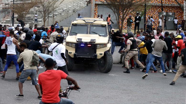 Armed off-duty police officers commandeer an armored vehicle during a protest over police pay and working conditions, in Port-au-Prince, Haiti, Sunday, Feb. 23, 2020.
