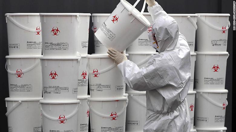 A worker in Daegu, South Korea, stacks plastic buckets containing medical waste from coronavirus patients on Monday, February 24.
