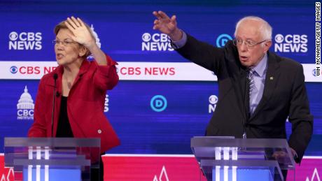 Democratic presidential candidates (L-R) Sen. Elizabeth Warren (D-MA) and Sen. Bernie Sanders (I-VT) raise their hands during the Democratic presidential primary debate at the Charleston Gaillard Center on February 25, 2020 in Charleston, South Carolina. 