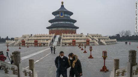 Chinese visitors wear protective masks as they tour the grounds of the Temple of Heaven, which remained open during the Chinese New Year and Spring Festival holiday on January 27, 2020 in Beijing, China. 