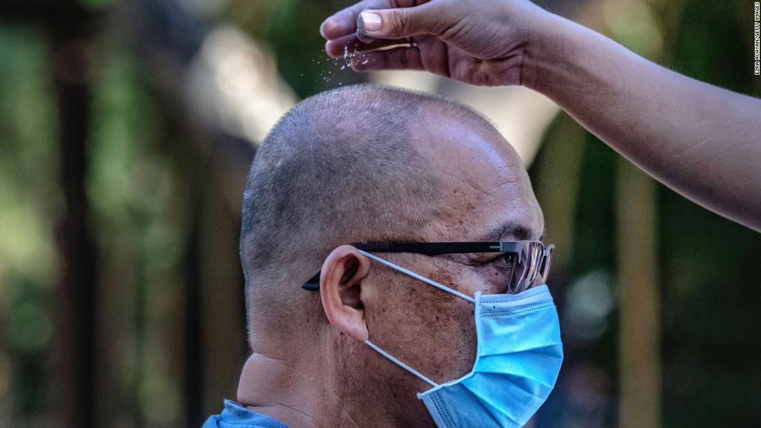 A Catholic devotee wears a face mask as he is sprinkled with ash during Ash Wednesday services in Paranaque, Philippines, on February 26, 2020.