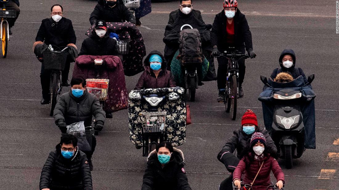 Commuters in Beijing wear protective masks as they ride bikes and scooters across an intersection during rush hour on February 24. Nearly everyone in Beijing and across mainland China is wearing a protective mask outdoors, if they go out at all; some instead choose to stay home as much as possible, in line with the government&#39;s recommendation to self-quarantine and avoid public gatherings.