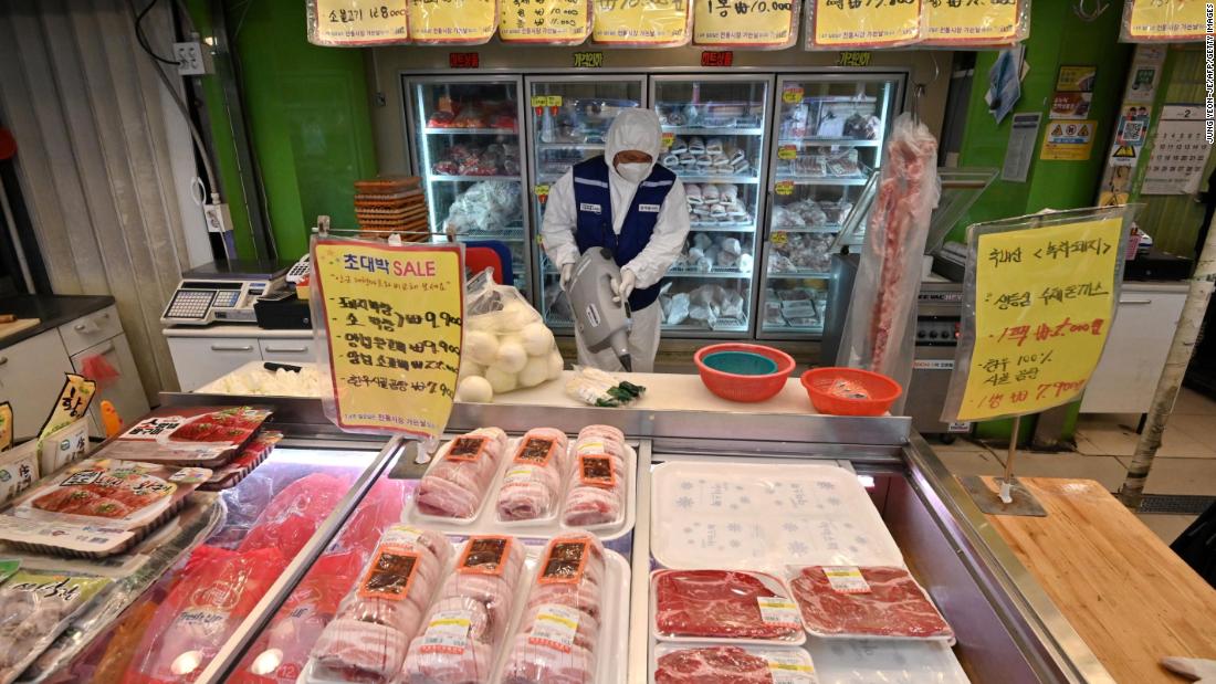 A worker from the Korea Pest Control Association, wearing protective gear, sprays disinfectant at a market in Seoul on February 24. South Korea has seen a spike in numbers as a new outbreak spreads across the country. There are now more than 1,500 cases nationwide, many of which are linked to a religious group in the south of the country.