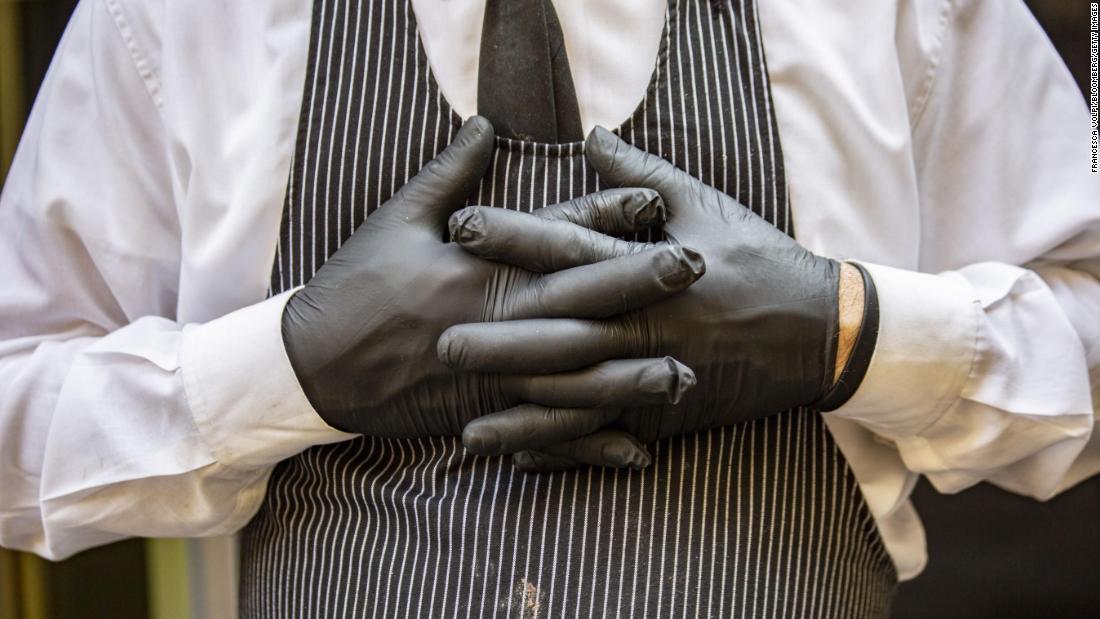 A worker wears disposable latex gloves while serving food at a cafe in Milan, Italy, on February 24. Italy is now the largest outbreak outside Asia, and is at the heart of the European outbreak. Since Italy&#39;s outbreak, the virus has spread to many other nearby countries; Norway, Denmark, Austria, Romania, Georgia, and North Macedonia all reported their first cases within a week.