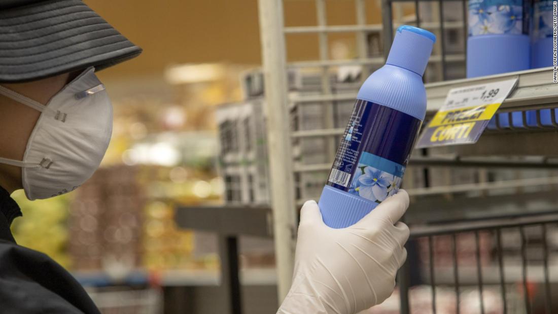 A customer wearing a protective face mask and gloves reads a cleaning product label in a grocery store in Milan, Italy, on February 25. Italian authorities are now scrambling to respond to the outbreak, after the prime minister was forced to admit that a hospital had mishandled the region&#39;s first coronavirus case and had contributed to the virus&#39; spread.