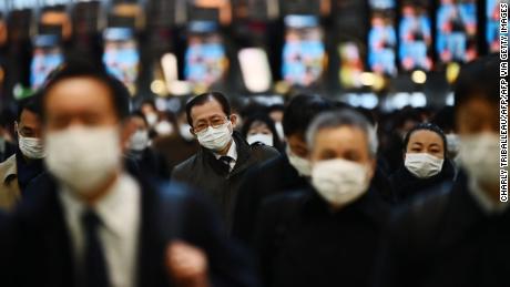 Mask-clad commuters make their way to work during morning rush hour at the Shinagawa train station in Tokyo on February 28, 2020. - Tokyo&#39;s key Nikkei index plunged nearly three percent at the open on February 28 after US and European sell-offs with investors worried about the economic impact of the coronavirus outbreak. (Photo by CHARLY TRIBALLEAU / AFP) (Photo by CHARLY TRIBALLEAU/AFP via Getty Images)