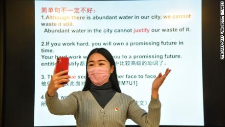 A teacher gives a lecture with her smart phone during an online class at a middle school in Donghai in China&#39;s eastern Jiangsu province on February 17, 2020. 