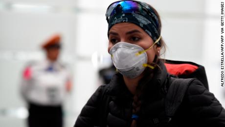 A passenger from a flight which originated in South Korea wears a protective face mask upon landing at Mexico City's international airport, on February 28, 2020 as the new coronoavirus, COVID-19, spreads worldwide. - Mexico's Health Ministry confirmed the country's first case of coronavirus on Friday, saying a young man had tested positive for it in the capital. (Photo by ALFREDO ESTRELLA / AFP) (Photo by ALFREDO ESTRELLA/AFP via Getty Images)