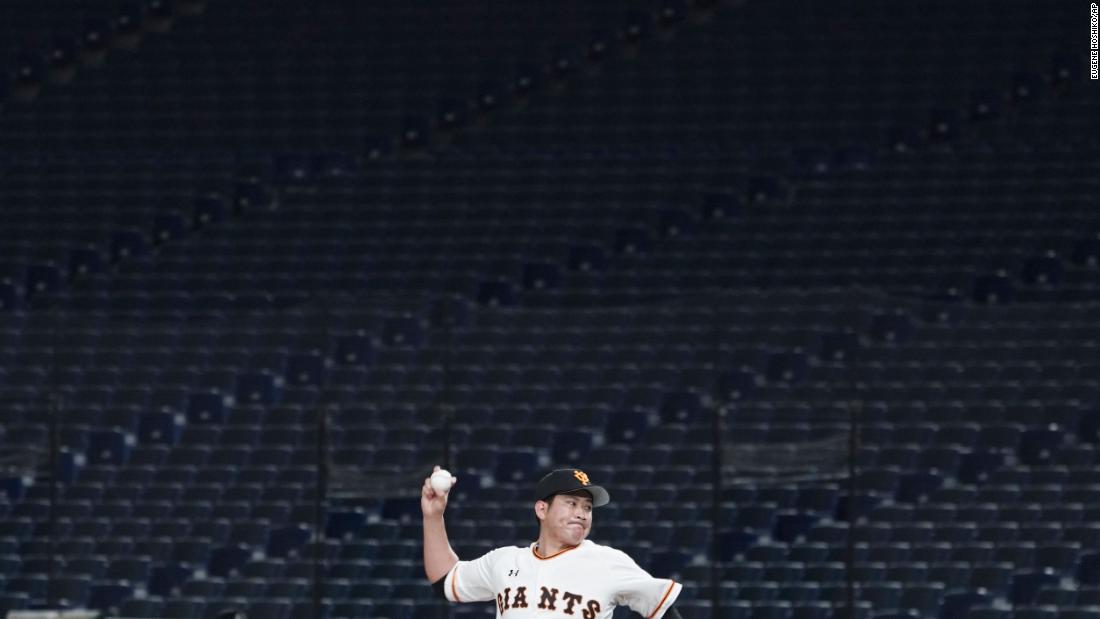 Tomoyuki Sugano, a professional baseball player on the Yomiuri Giants, throws a pitch in an empty Tokyo Dome during a preseason game on February 29, 2020. Fans were barred from preseason games to prevent the spread of the coronavirus.