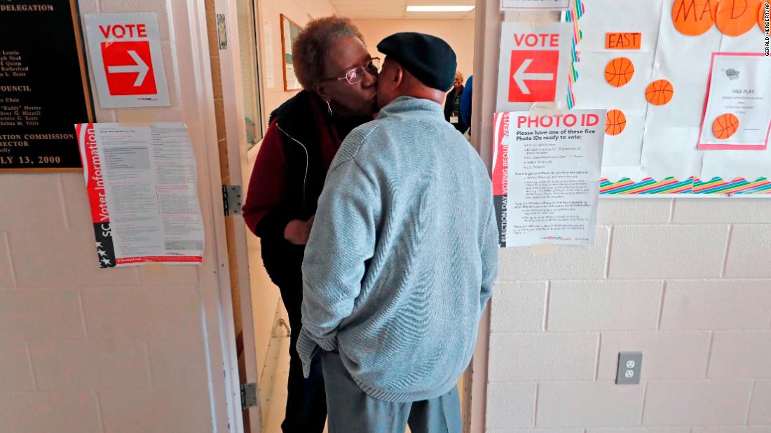 Bernice Scott kisses the cheek of friend Harry Thompson as he arrives to vote in Hopkins.