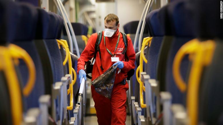 A worker sanitizes a car on a regional train in Milan on Friday.