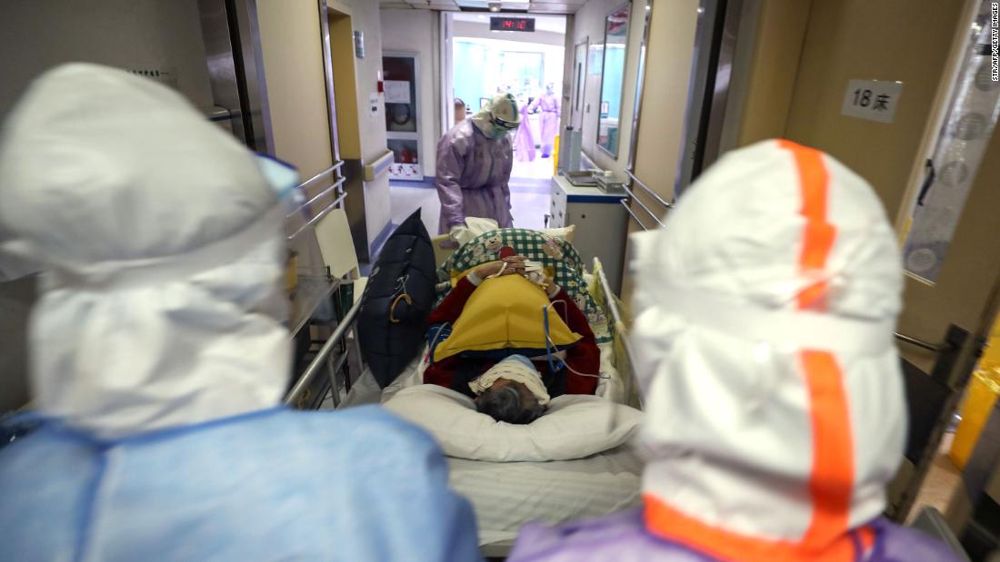 Medical staff transport a coronavirus patient within the Red Cross hospital in Wuhan on February 28, 2020. 