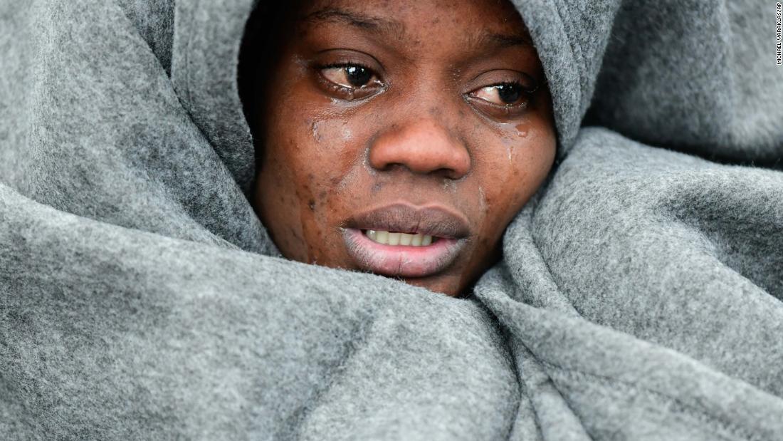 After arriving in the Greek village of Skala Sikaminias, a migrant cries as she tries to warm herself.