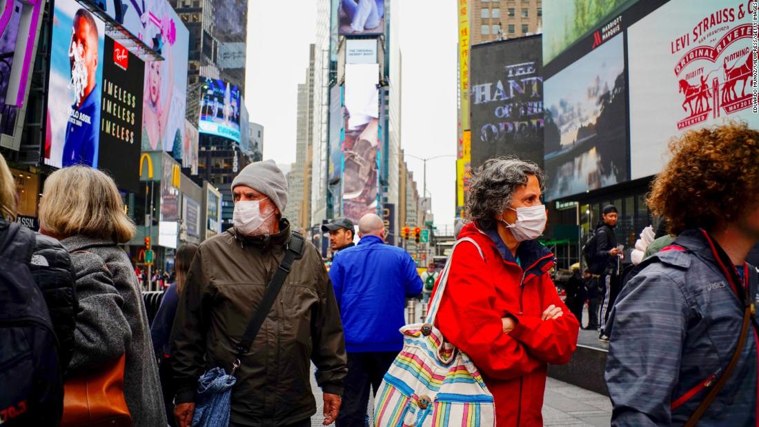 People wear face masks in New York's Times Square on March 3, 2020. New York reported its first case of coronavirus two days earlier. 