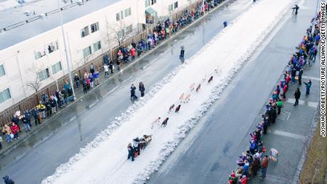 Scott Janssen, known as the &quot;Mushin&#39; Mortician,&quot; waves to the crowd as he mushes down Fourth Avenue in Anchorage on March 7, 2015. 