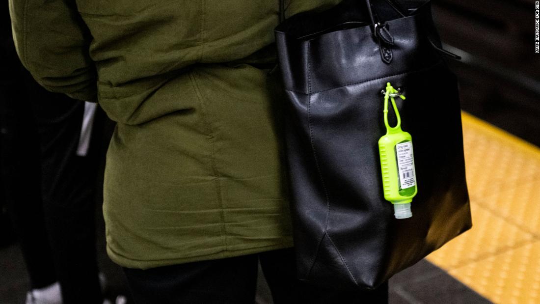 A hand sanitizer dispenser hangs from a subway rider's bag at the Times Square station in Manhattan. 