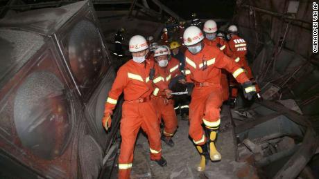 Rescuers evacuate an injured person from the rubble of a collapsed hotel building in Quanzhou city in southeast China&#39;s Fujian province.