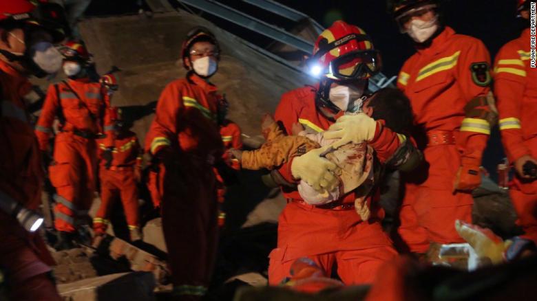 Rescuers carried a young boy from the rubble. 