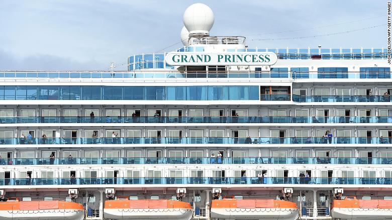 Passengers look out from aboard the Grand Princess cruise ship, operated by Princess Cruises, as it maintains a holding pattern about 25 miles off the coast of San Francisco, California on Sunday.