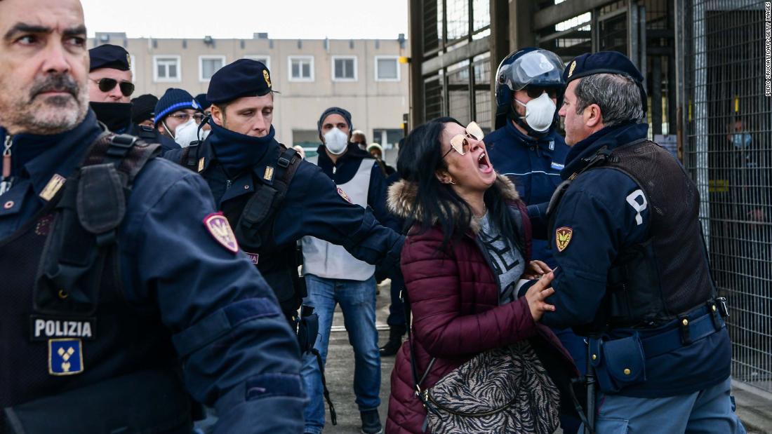 Police officers restrain the relative of an inmate outside the Sant&#39;Anna jail in Modena, Italy, on March 9. &lt;a href=&quot;http://www.cnn.com/asia/live-news/coronavirus-outbreak-03-09-20-intl-hnk/h_950c62671e245816c223fb84f1306fe6&quot; target=&quot;_blank&quot;&gt;Riots broke out&lt;/a&gt; in several Italian jails after visits were suspended to curb the spread of the coronavirus.