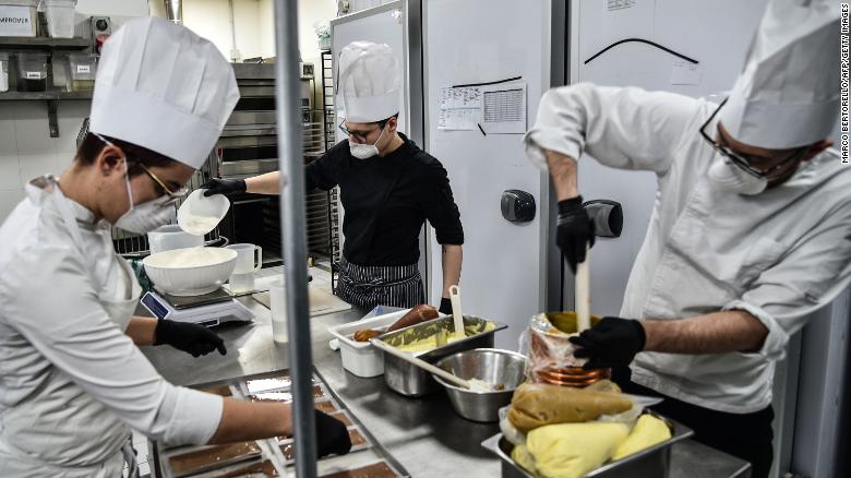 Employees of Turin's famed pastry shop "Gerla" wear respiratory masks while cooking.