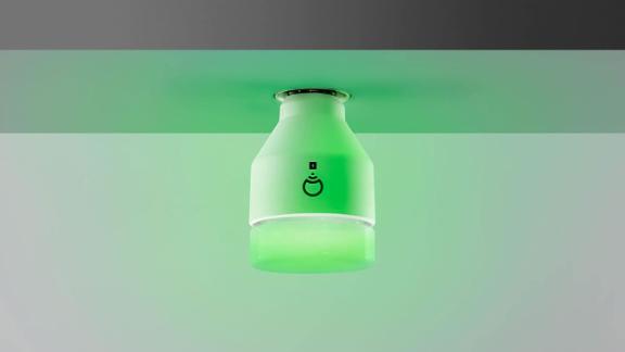 A LIFX smart bulb glowing green.