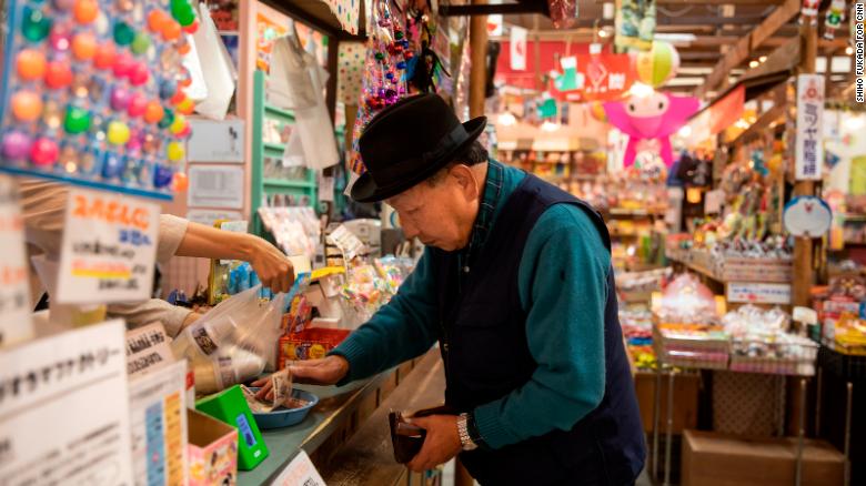 Iwao Hakamada buys himself an ice cream as he takes his daily walk around Hamamatsu,