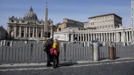A couple looks at the closed St. Peter&#39;s Square at the Vatican on Monday, after a decree ordering restrictions across Italy to beat the spread of the coronavirus.