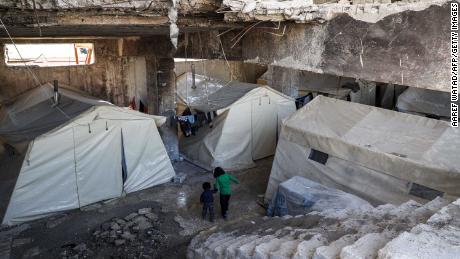 Syrian children displaced by the war walk at an underground makeshift camp at Idlib football stadium on March 3, 2020.