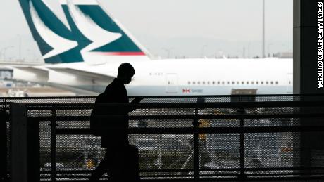 A passenger wearing a face mask walks past Cathay Pacific aircraft parked at Kansai International Airport on Tuesday in Osaka, Japan. 