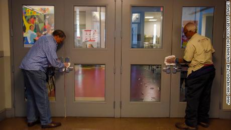 Volunteers at Central Union Mission men&#39;s homeless shelter disinfect surfaces in Washington DC.