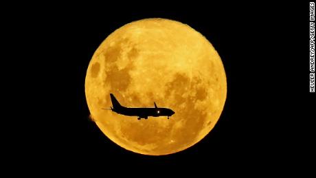 This image, taken in Brazil, shows a plane passing in front of the supermoon in March 2020. 
