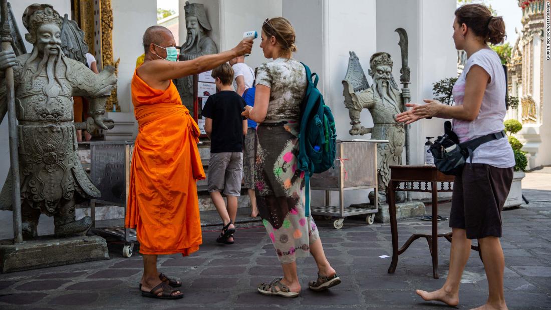 Body temperatures are scanned as people enter the Buddhist temple Wat Pho in Bangkok, Thailand.