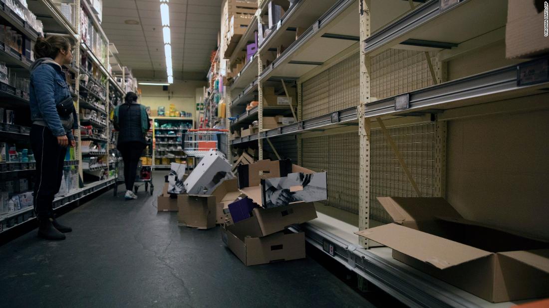 A woman looks at an empty bread aisle in Antwerp, Belgium, on March 13, 2020.