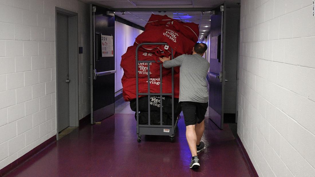 Paul Boyer, head equipment manager of the NHL&#39;s Detroit Red Wings, wheels out equipment bags in Washington on March 12. The NHL is among the sports leagues that have suspended their seasons.