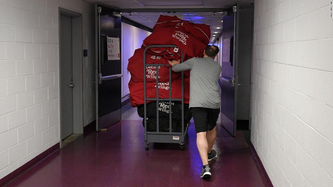 Paul Boyer, head equipment manager of the NHL&#39;s Detroit Red Wings, wheels out equipment bags in Washington on March 12, 2020. The NHL was among the sports leagues that had suspended their seasons.